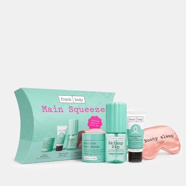 A Frank Body Main Squeeze skincare gift set featuring a mint green box, a body dip bottle, a body scrub tube, a body lotion tube, and a pink satin sleep mask on a light gray background.