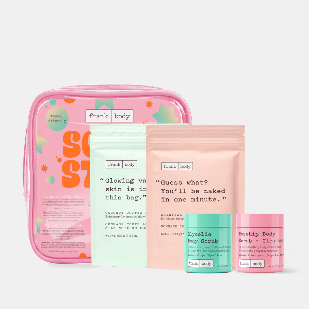 The frank body Scrub Stars Kit laid out with a clear pink travel bag, the Coconut Coffee Scrub and Original Coffee Scrub pouches and the Glycolic and Rosehip scrub tubs.