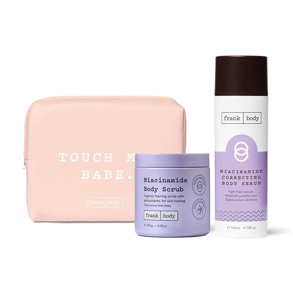 The frank body Niacinamide Era Kit: Niacinamide Body Scrub and Niacinamide Correcting Body Serum with a pink Touch Me Babe pouch.