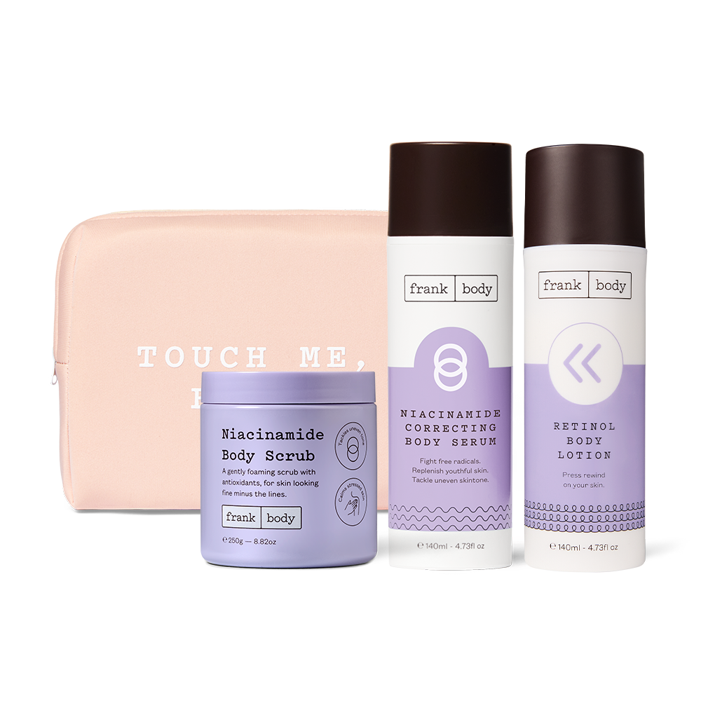 The frank body Time Machine Kit: Niacinamide Body Scrub, Niacinamide Correcting Body Serum and Retinol Body Lotion with a pink Touch Me Babe pouch.