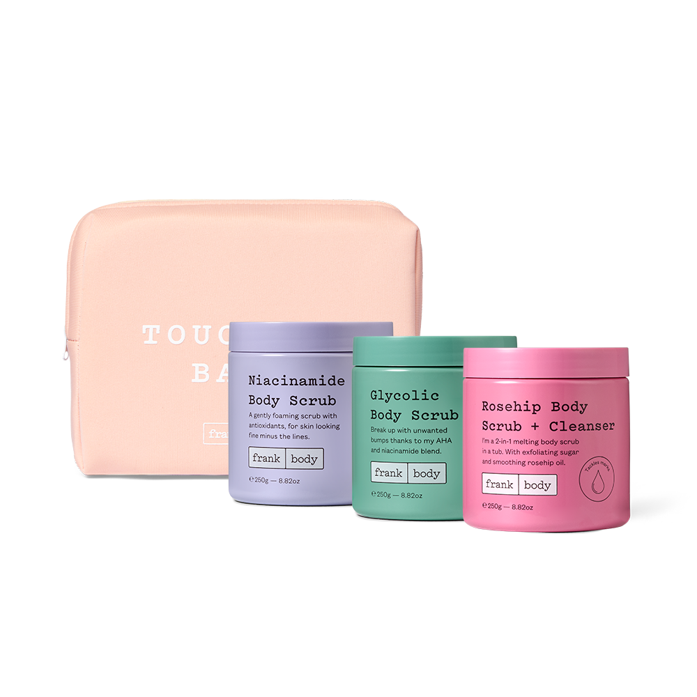 The frank body Triple Tub Rub Kit: Niacinamide Body Scrub, Glycolic Body Scrub and Rosehip Body Scrub + Cleanser with a pink Touch Me Babe pouch.