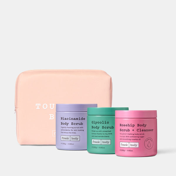 Set of four body scrubs and a pink pouch on a white background