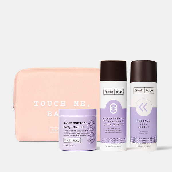 The frank body Time Machine Kit: Niacinamide Body Scrub, Niacinamide Correcting Body Serum and Retinol Body Lotion with a pink Touch Me Babe pouch.