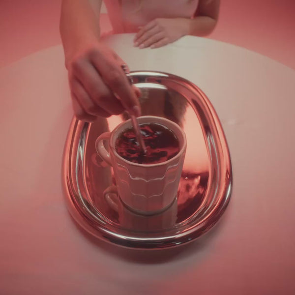 frank body Triple Shot gift set video: a model with a coffee cup unboxes the kit, spritzes fragrance mist and applies lip treatment against a peach backdrop.